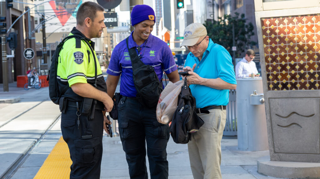 two Valley Metro security officers assist a rider