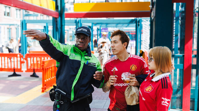 Sound Transit security personnel assists two soccer fans.