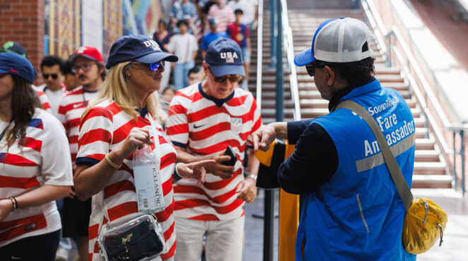 A fare ambassador assists two fans at Pioneer Square Station after Seattle's second world cup game between the USA and Australia on June 19, 2026.