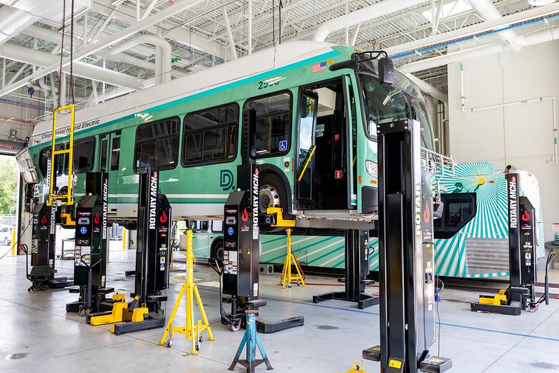 A bus on lifts in a new bright facility. 
