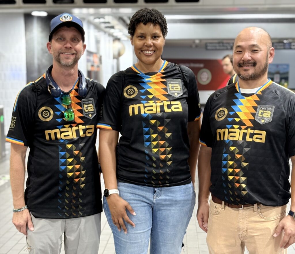 Three MARTA transit ambassadors pose wearing MARTA shirts.