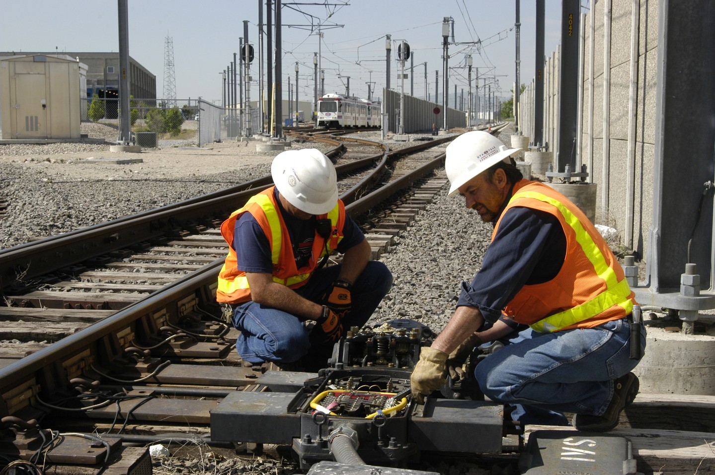 Two construction workers on a railroad.