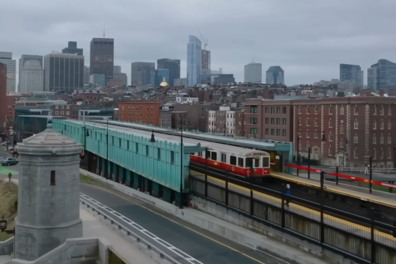 A train with a city in the background. 