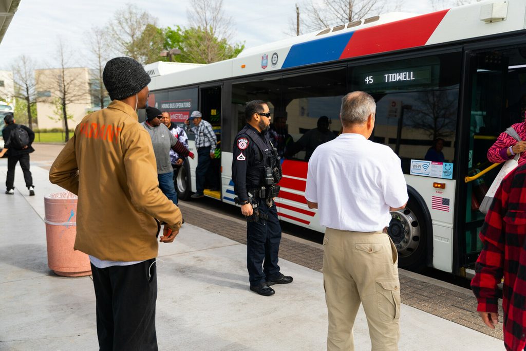 An officer stands outside a Houston METRO bus. 