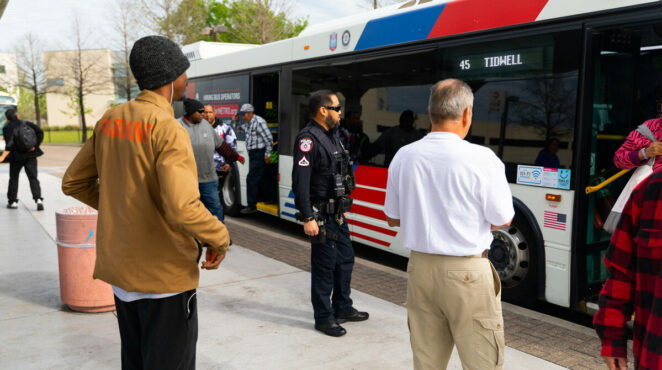 An officer stands outside a Houston METRO bus.
