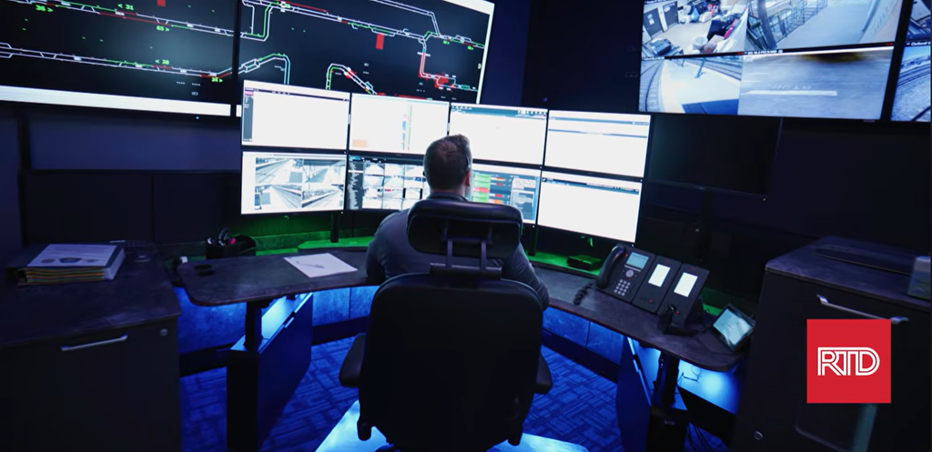 An RTD dispatcher in front of many small and large display screens.