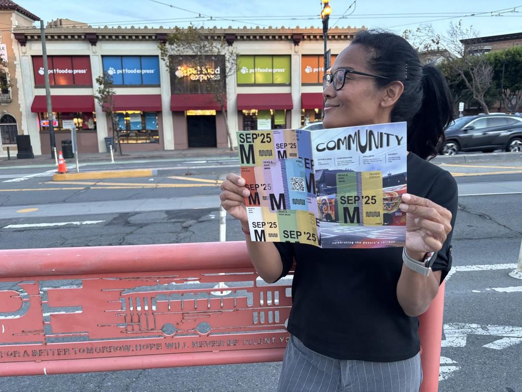A woman holds a copy of Community magazine.